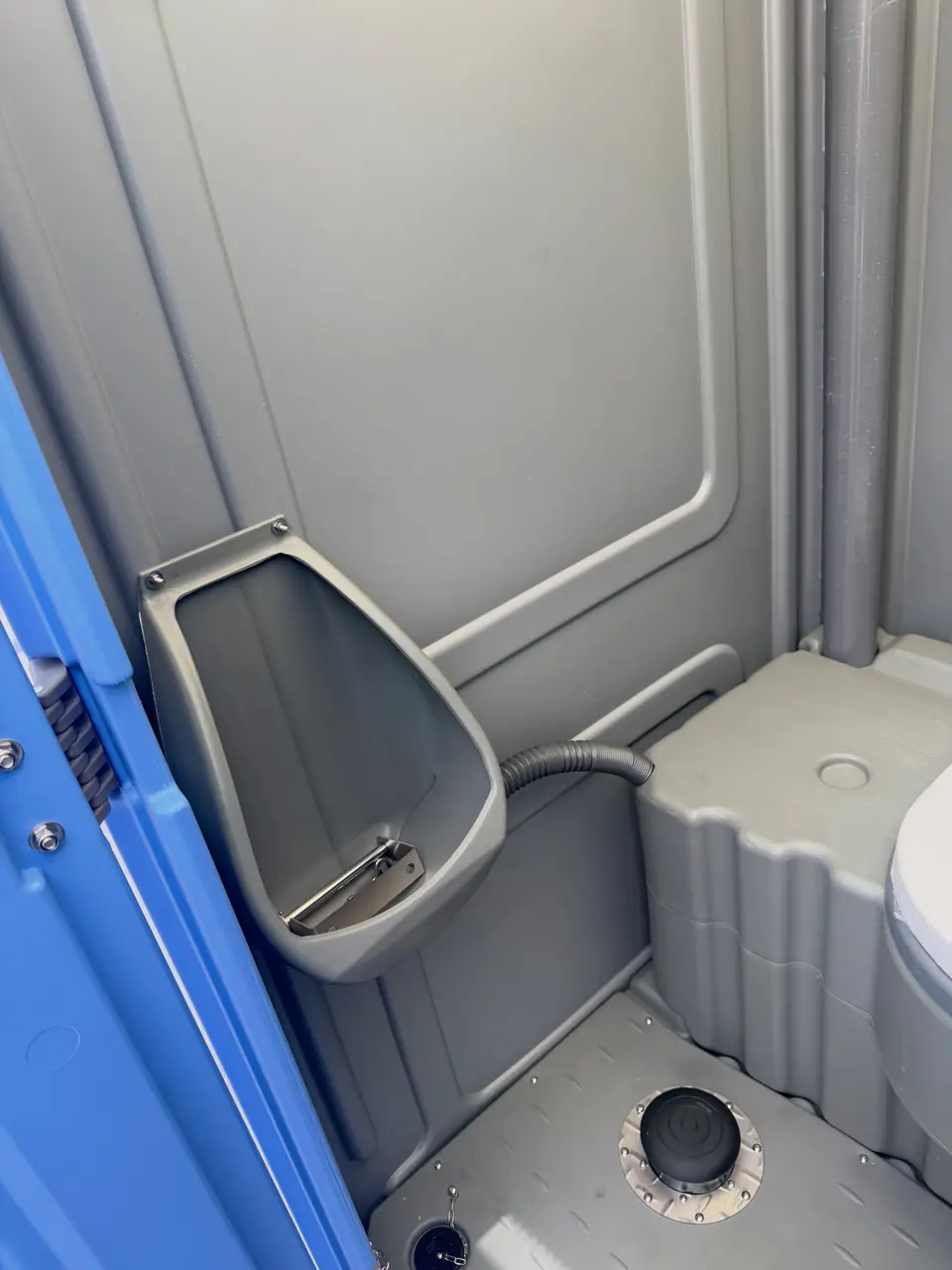 Urinal and toilet seat inside a standard construction porta potty